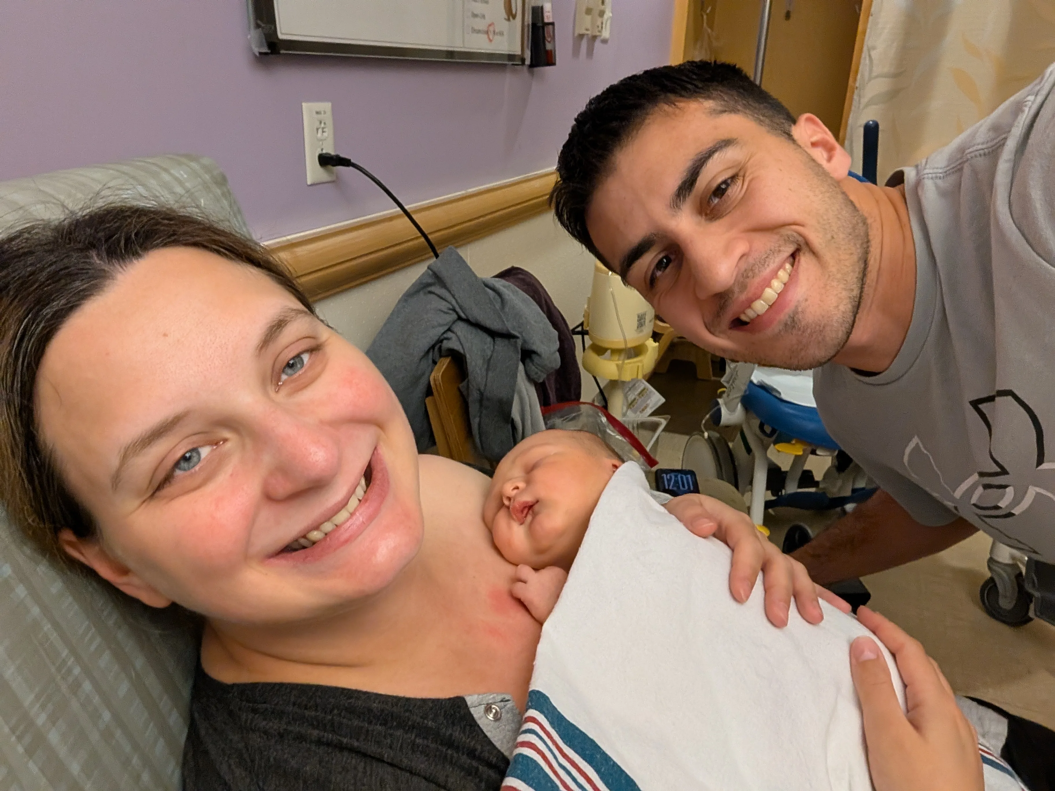 Amanda beaming in the hospital on Mother's Day with newborn Nolan on her chest, Mark leaning in alongside